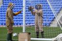 Beekeepers remove the bees from the pitch (Picture: Kipax)
