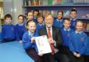 Headteacher David Coulbeck celebrates with seven-year-old Lauren Green and the rest of Moulton School council.