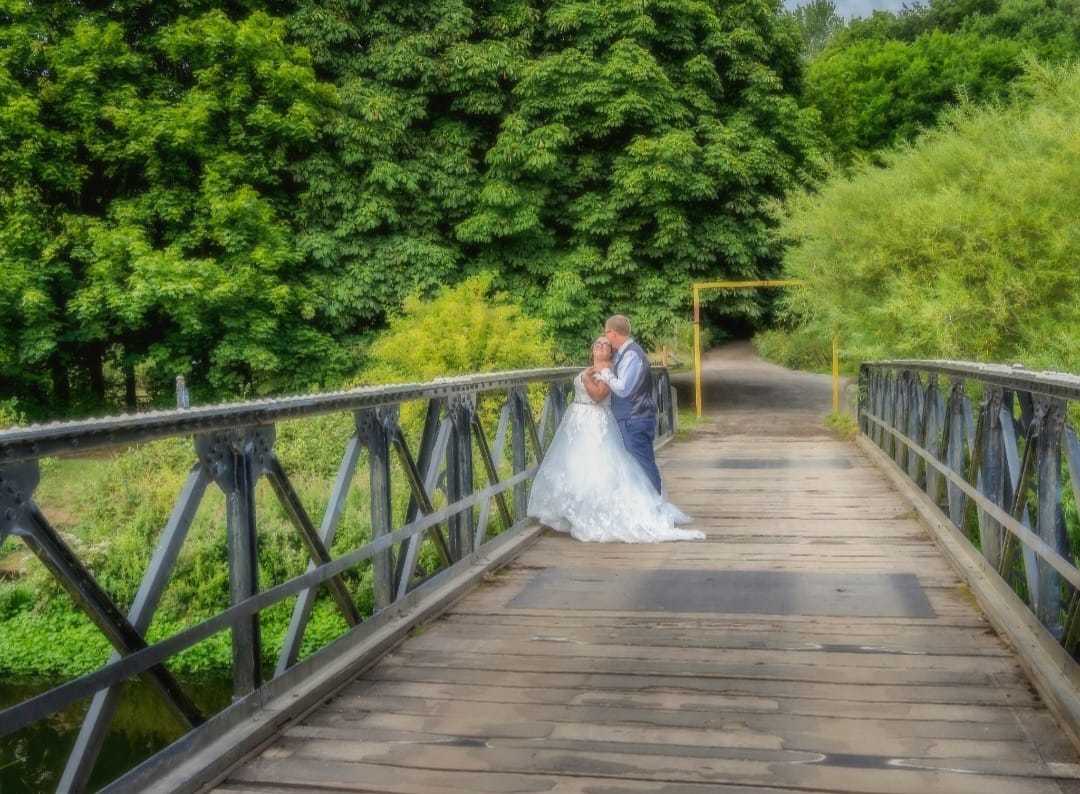 Newlyweds on an old bridge by Donna Maria Long