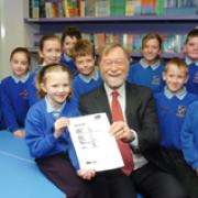 Headteacher David Coulbeck celebrates with seven-year-old Lauren Green and the rest of Moulton School council.