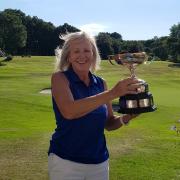 Ruth Elliot-Smith lifts the Sheila Watson Trophy at Sandiway Golf Club
