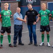 1874 Northwich’s multi-year sponsor agreement is done as chairman Stephen Richardson shakes hands with Shadow Foam’s Jonathan Shone watched by members of the playing squad