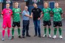 1874 Northwich’s multi-year sponsor agreement is done as chairman Stephen Richardson shakes hands with Shadow Foam’s Jonathan Shone watched by members of the playing squad