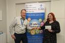 Lottery winner Laura Wakeling receives her cheque from Andy Bailey from St Luke’s fundraising team