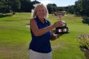 Ruth Elliot-Smith lifts the Sheila Watson Trophy at Sandiway Golf Club