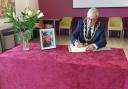 Northwich town mayor Cllr Graham Emmett signs a book of condolence