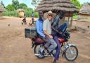 Jerry Marshall with two of his hosts, travelling on a 'boda boda'