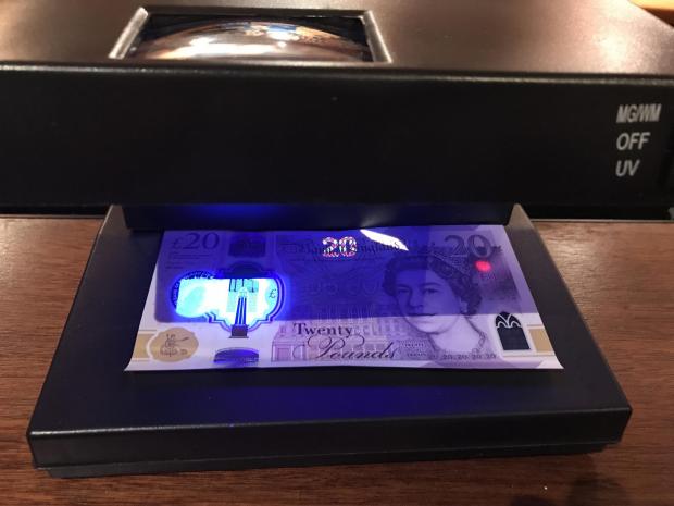 Northwich Guardian: A genuine £20 note under one of the UV scanners in Northwich