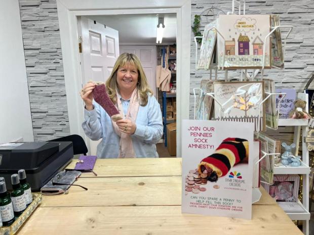 Northwich Guardian: Susie from Chapel Gift Company proudly shows off the businesses sock for charity