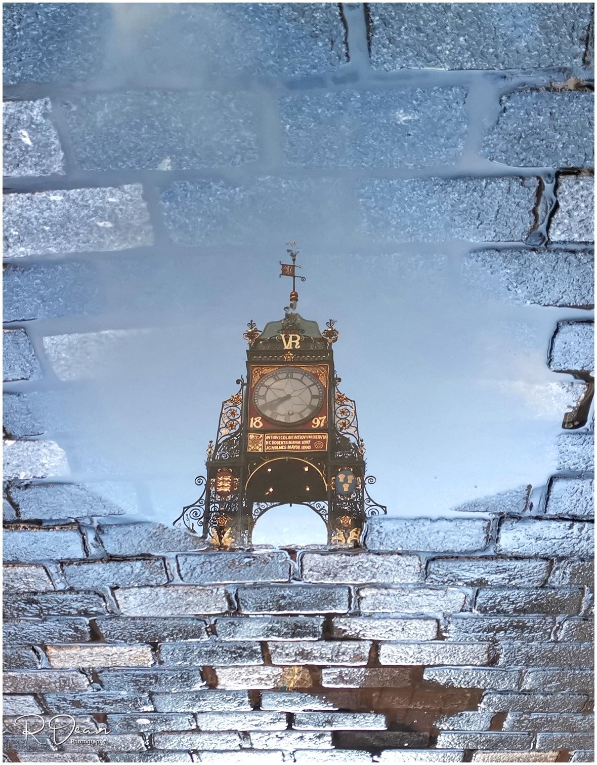 Eastgate Clock reflection on the cobbles in Chester by Russell Dean