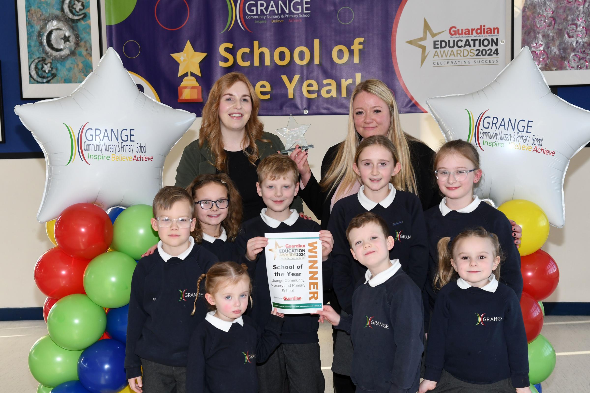 Headteacher Sara Albiston and assistant headteacher Harriet McGilloway celebrate winning School of the Year with pupils at Grange Community Nursery and Primary School
