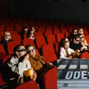 (Background) People in a cinema. Credit: Canva.(Rectangle) Odeon cinema sign. Credit: PA.