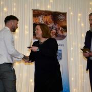 James Dubber being presented with an award for Youth Worker of the Year from sponsors Sarah Saward and Gary Hood, Weaver Vale Housing Trust